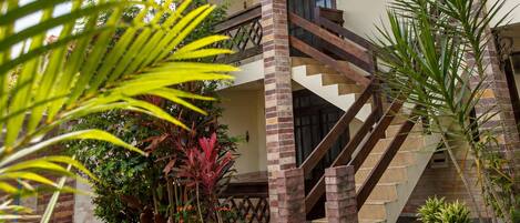 A two-story building with a brick staircase leading to the upper floor.