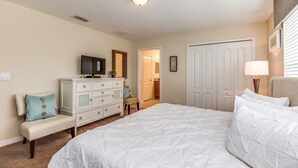 A bedroom with a bed, a dresser, a bench, and a door. - Lake View Private Pool Townhome - Sleeps 10 (Kissimmee)
