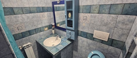 Un baño con lavabo, inodoro y espejo.