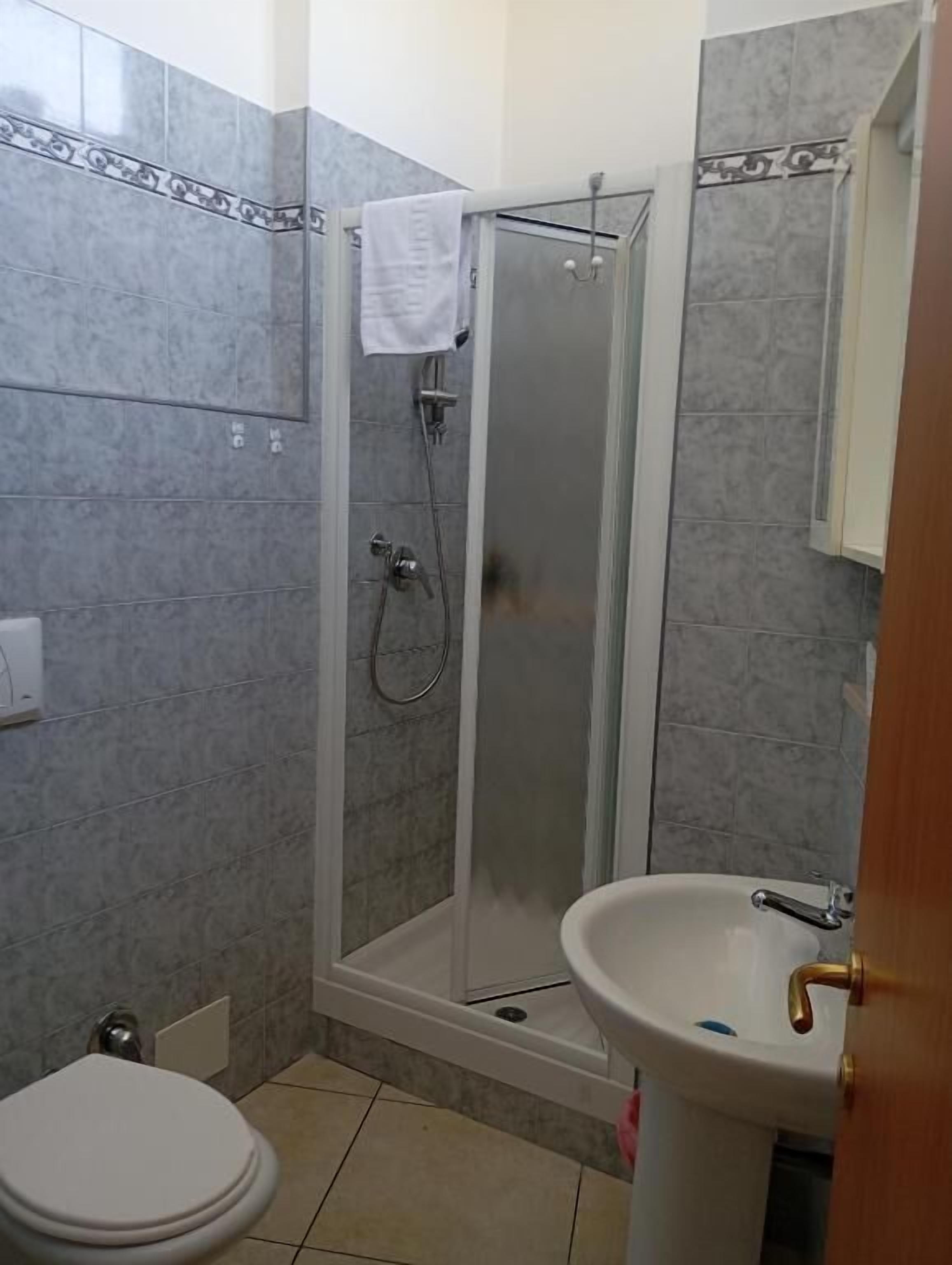 Une salle de bain avec une douche, des toilettes et un lavabo.