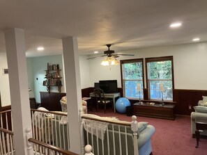 A living room with a television, exercise ball, and bookshelf. - Southern charm - two bedrooms close to the beach and to Charleston! (Mount Pleasant)