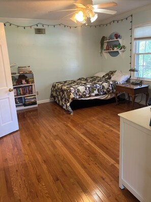 A bedroom with a bed, a desk, a bookshelf, and a window. - Southern charm - two bedrooms close to the beach and to Charleston! (Mount Pleasant)