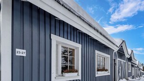 Une rangée de maisons avec un numéro, « 23-27 », inscrit sur le mur, indiquant qu’il s’agit d’un immeuble dont les logements sont numérotés.