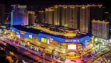 A multi-story hotel with a prominent entrance and a large illuminated sign.