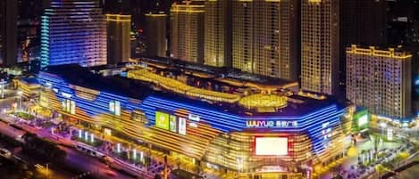 A multi-story hotel with a prominent entrance and a large illuminated sign.