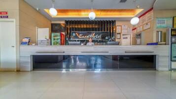 A hotel reception area with a counter, a television screen, and a sign that reads 'East Hotel.'