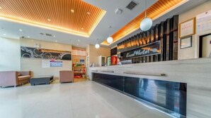 A hotel reception area with a modern design, a reception desk, seating area, and a visible menu board. - MengDao Holiday Hotel(Yichang China Three Gorges University) (Yichang)