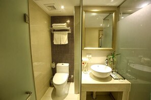 Et badeværelse med toilet, håndvask og spejl.