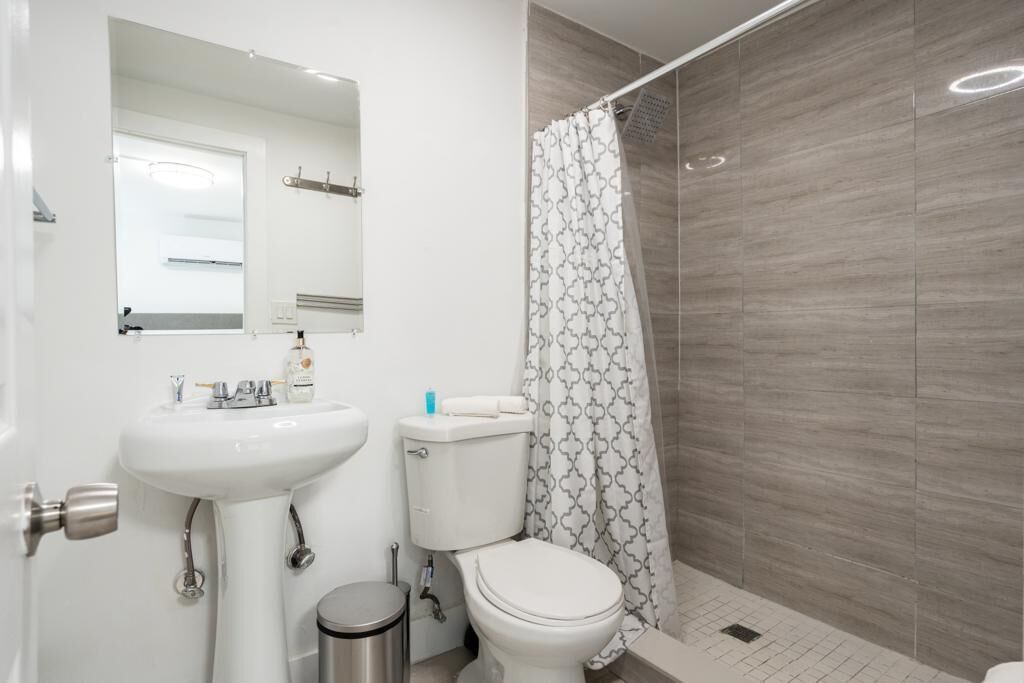 Een badkamer met een wit wastafel, toilet en douchegordijn.