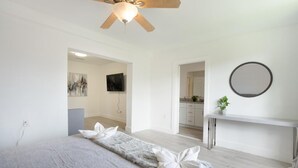 A bedroom with a bed, a ceiling fan, a TV, a mirror, and a small plant. - Spacious 4-bedroom house  with AC  15 minutes from Miami airport/ 14 ppl (Miami)