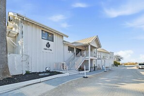Een gebouw met een bord waarop 'FARM & FIRE' staat, een trap en een overdekt buitengebied.