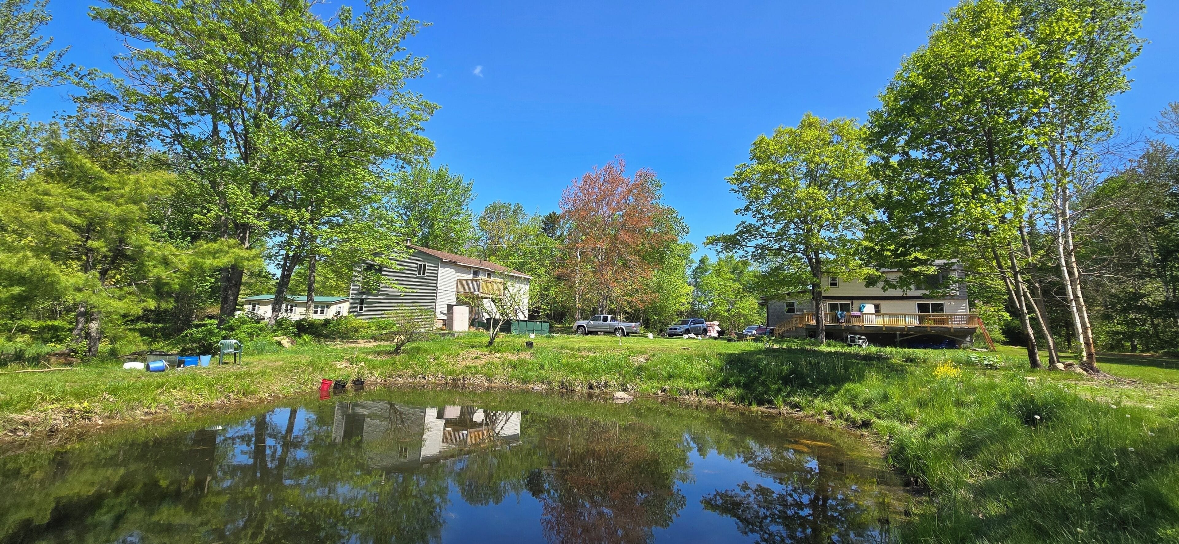 Une propriété au bord du lac, comprenant une maison, un quai et un petit étang.