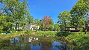 Une propriété au bord du lac, comprenant une maison, un quai et un petit étang.
