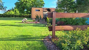 Un jardin bien entretenu, agrémenté d’une clôture en bois, d’un petit abri de jardin et d’une pelouse verdoyante.