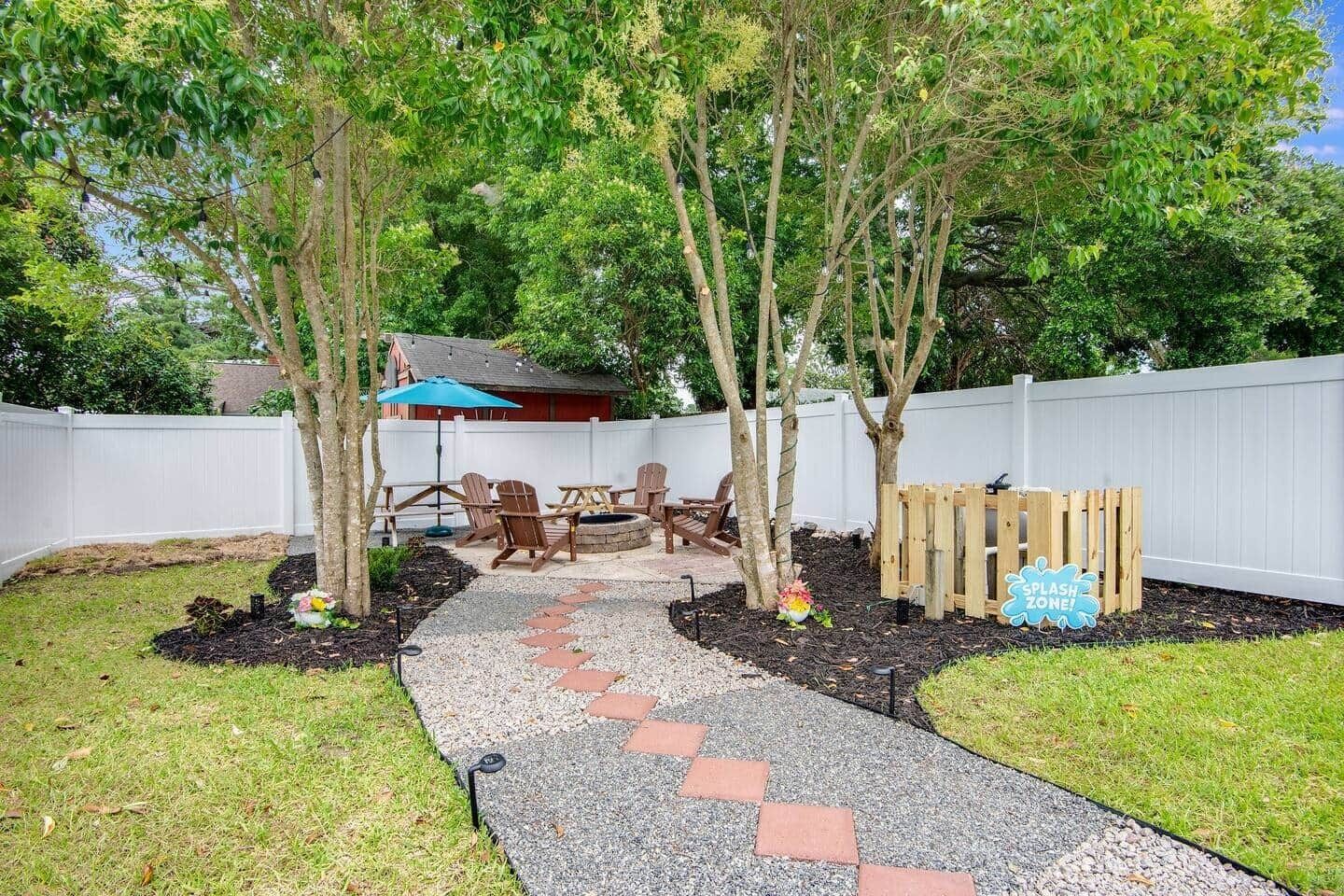 Un patio trasero con zona de estar y cerco de madera.