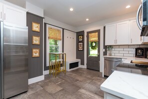 A modern kitchen with white cabinets, a stainless steel refrigerator, and a built-in oven. - Fully restored historic 1911 three bedroom, two bath home in Middletown OH (Middletown)
