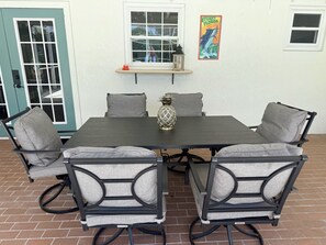Une table à manger avec quatre chaises, un vase décoratif et un panneau mural.