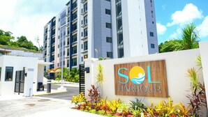 Un edificio moderno con un letrero que dice 'SOL HARBOUR' y una entrada protegida por una puerta.