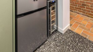 A compact kitchen with a microwave, a small refrigerator, and a built-in oven. - Stylish studio apartment opposite Carlton Gardens (Carlton)