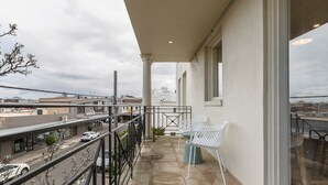 A balcony with a view of the street, a white chair, and a table. - Stylish, Spacious Apartment in Malvern (Malvern)