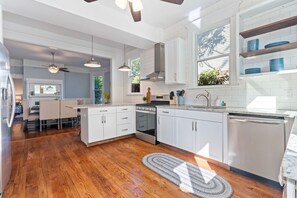 A modern kitchen with white cabinetry, a built-in oven, and a dishwasher.