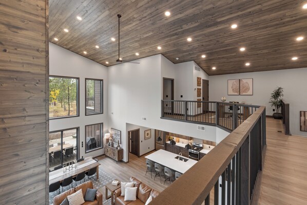 A spacious interior with a high ceiling, large windows, and a mezzanine level. - Spacious 4-bedroom house in tranquil Lead with AC and game room (Lead)