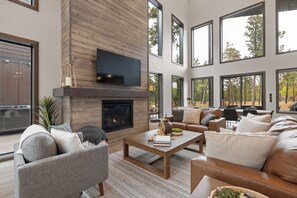 A spacious living room with a fireplace, comfortable seating, and large windows offering a view of the outdoors. - Spacious 4-bedroom house in tranquil Lead with AC and game room (Lead)