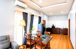 Un espacio habitable compacto con comedor, kitchenette y zona de estar.