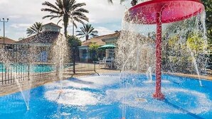 Un aménagement paysager comprenant plusieurs fontaines, une piscine et des palmiers.