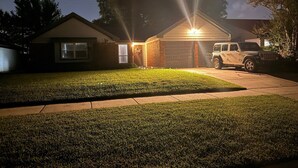 Una casa residenziale con garage, vialetto e prato.