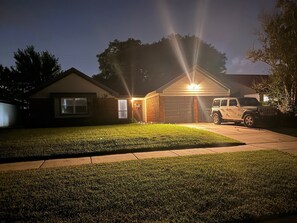 Ein Wohnhaus mit Garage, Auffahrt und Rasen.