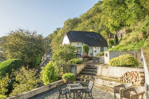 A hillside property with a house, outdoor seating, and a staircase leading up. - 2-Bed Cottage Devon/Cornwall border - Dog-friendly (Newbridge, Gunnislake)