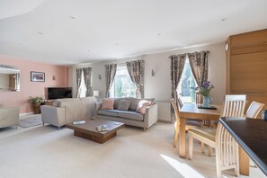A modern living room with a sofa, a coffee table, and a dining area with a table and chairs. - 2-Bed Cottage Devon/Cornwall border - Dog-friendly (Newbridge, Gunnislake)