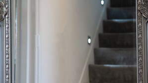 Eine Treppe mit Teppichstufen und Wandleuchten.