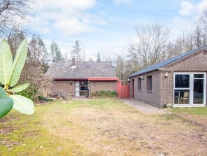 A two-story brick house with a red roof, a satellite dish, and a large window. - 10 Person Holiday Home in Herning (Herning)