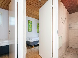 A room with a bed, a small bedside table, and a wall-mounted heater. - 10 Person Holiday Home in Herning (Herning)
