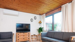 A living room with a television, sofa, wooden cabinet, and a small table. - 10 Person Holiday Home in Herning (Herning)