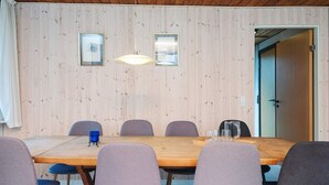 A wooden-paneled room with a long table, six chairs, and two pendant lights. - 10 Person Holiday Home in Herning (Herning)