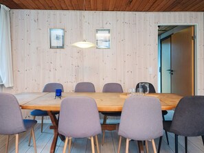 A wooden-paneled room with a long table, six chairs, and two pendant lights. - 10 Person Holiday Home in Herning (Herning)