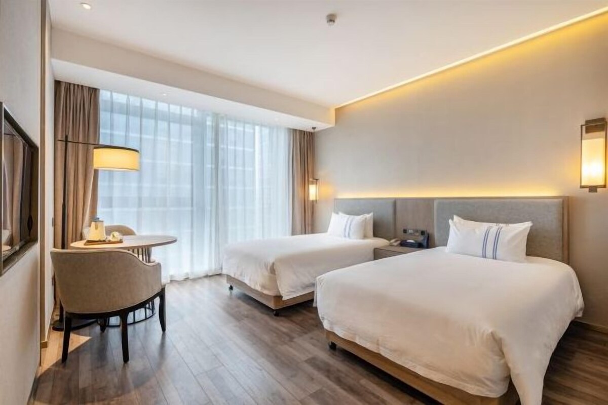 Una habitación de hotel con dos camas, un escritorio y una silla.