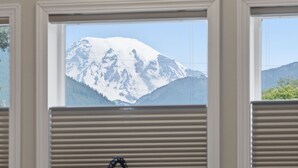 Cozinha com vista para montanhas nevadas através de grandes janelas.