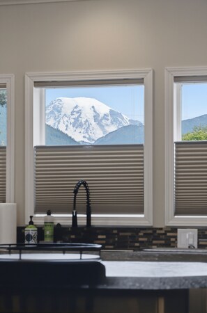 Eine Küche mit Blick auf schneebedeckte Berge durch große Fenster.