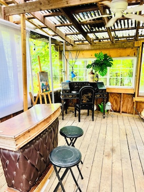A wooden deck with a bar area, a table with chairs, and a window with a view of greenery. - Private 2BR Finger Lakes Retreat Near Wineries & Seneca Lake (Hector)