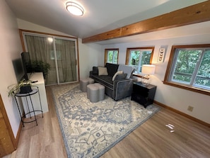 A living room with a sofa, ottomans, a rug, a lamp, and a television. - Private 2BR Finger Lakes Retreat Near Wineries & Seneca Lake (Hector)