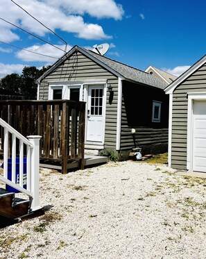 A residential property with a gravel driveway, a wooden fence, and a satellite dish. - Quiet and charming efficiency Cottage in historic Old Town (Somers Point)