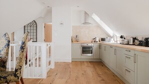 A modern kitchen with a built-in oven, a microwave, and a coffee machine. - The Coach House - Beautiful 3 Bedroom Home in Oxfordshire (Souldern)