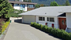 A paved pathway leading to a row of cabins with a mountain backdrop.