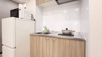 Departamento estándar, balcón, vista a la ciudad | Cocina privada | Refrigerador, microondas, parrilla de estufa y utensilios de cocina