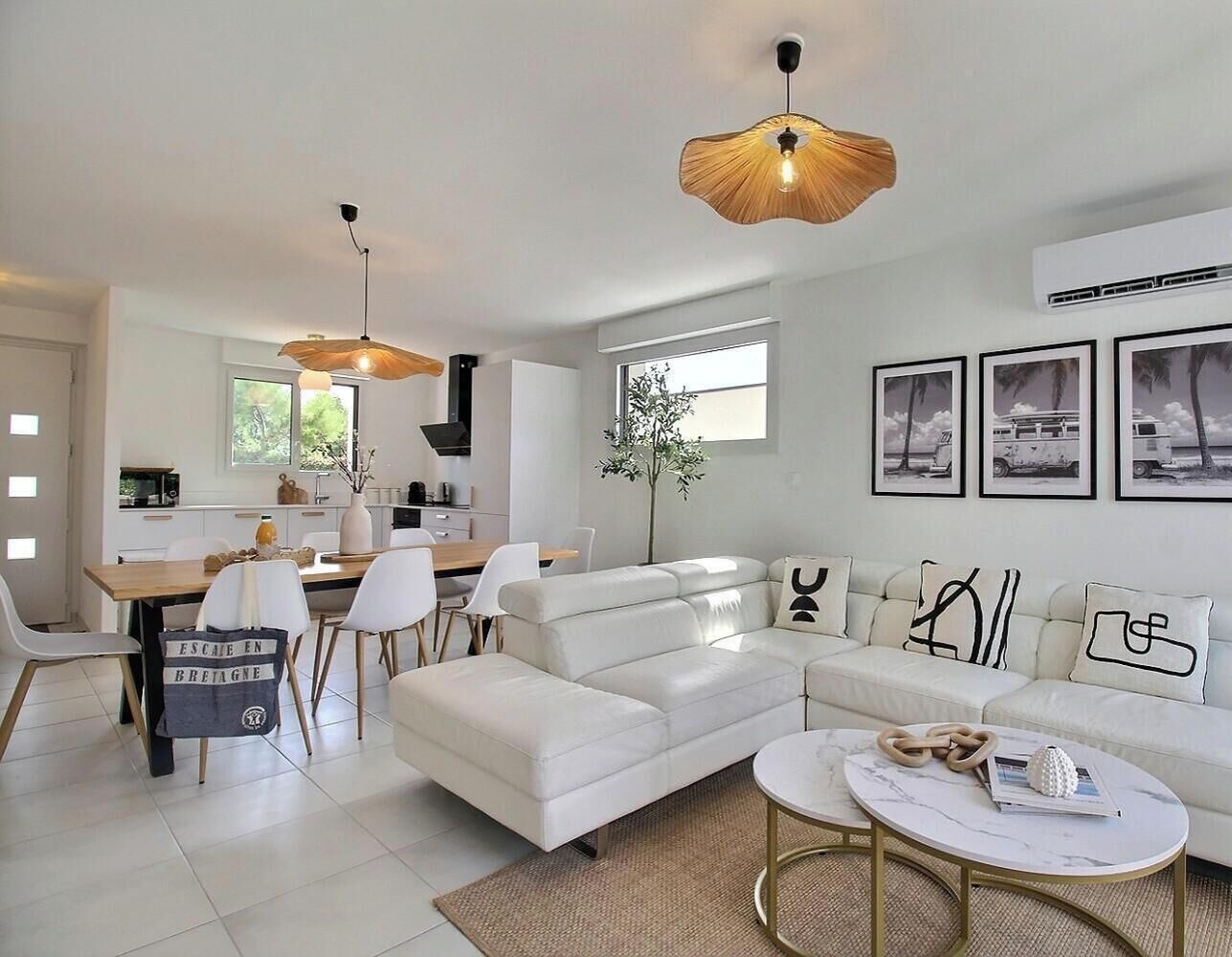 Una sala de estar moderna con sofá, mesa de centro y comedor.