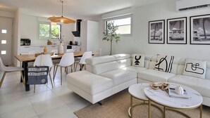 Una sala de estar moderna con sofá, mesa de centro y comedor.